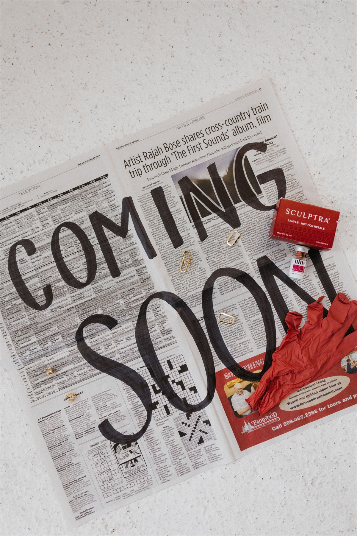 A newspaper hand-lettered with &ldquo;Coming Soon,&rdquo; styled with a Sculptra box and treatment gloves.